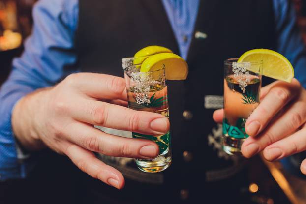 Hand holding a glass with vodka shot.