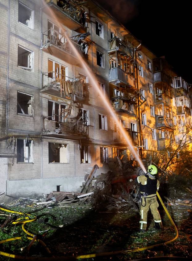 Firefighters work at the site of an apartment building hit by a Russian missile strike in Kyiv