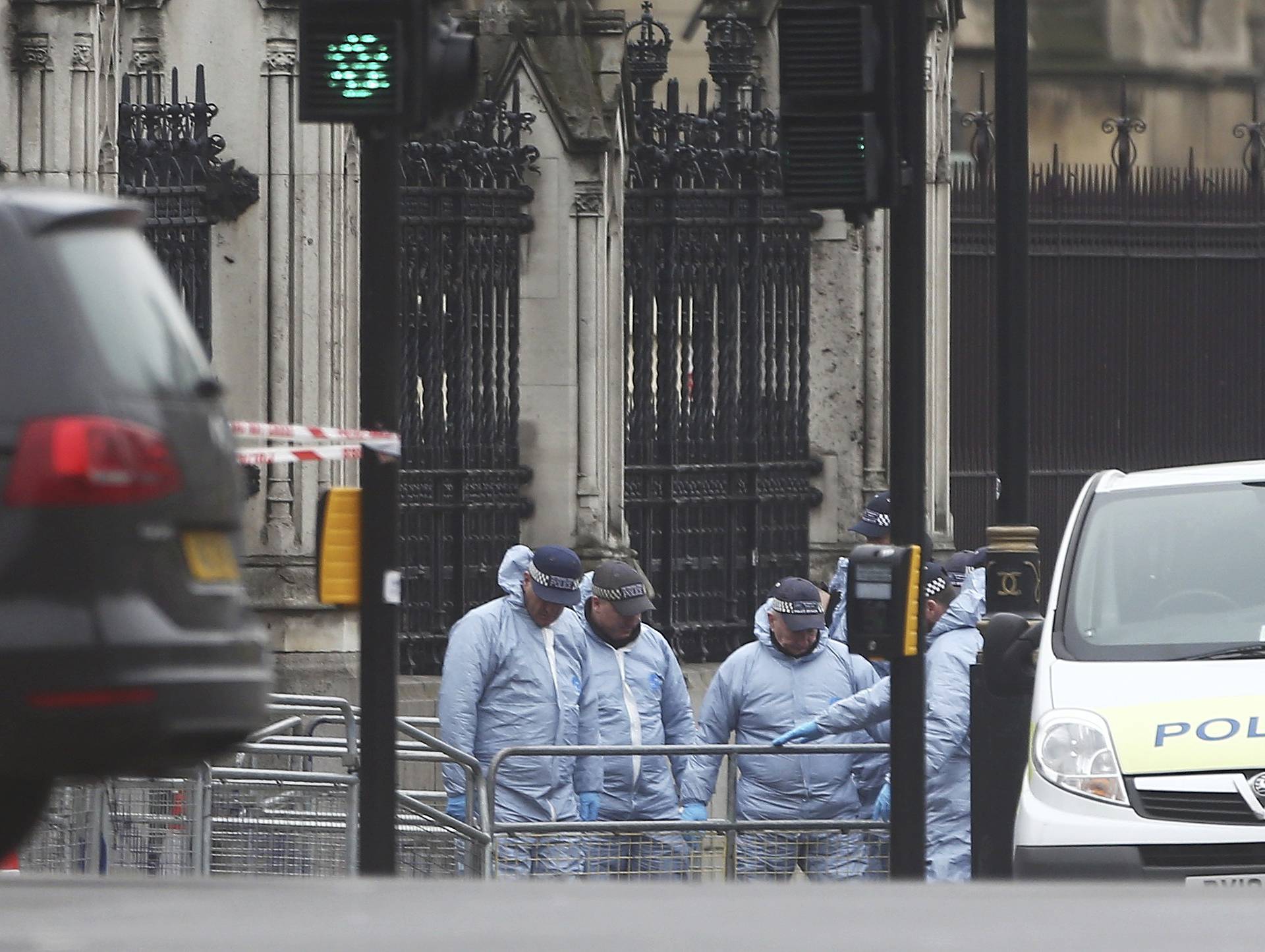Police work at Carriage Gate outside the Houses of Parliament the morning after an attack by a man driving a car and weilding a knife left five people dead and dozens injured, in London
