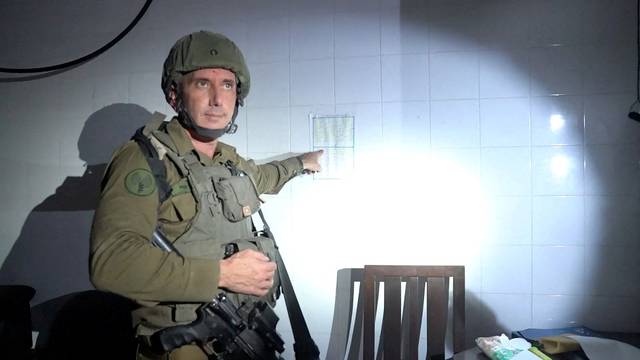 FILE PHOTO: Israeli military spokesperson Rear Admiral Daniel Hagari points at what he says is a guard roster in a room the military suspects was used by Hamas to hold hostages in the basement of Rantissi Hospital
