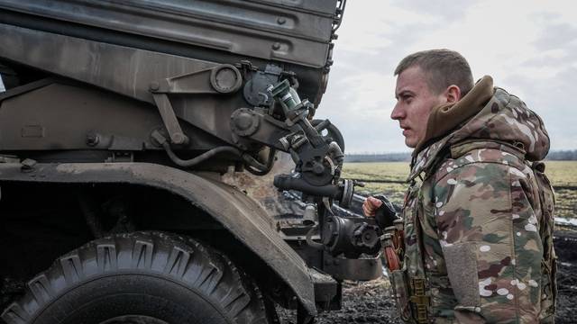 Ukrainian serviceman prepares to fire a BM-21 Grad multiple launch rocket system towards Russian troops in Donetsk region