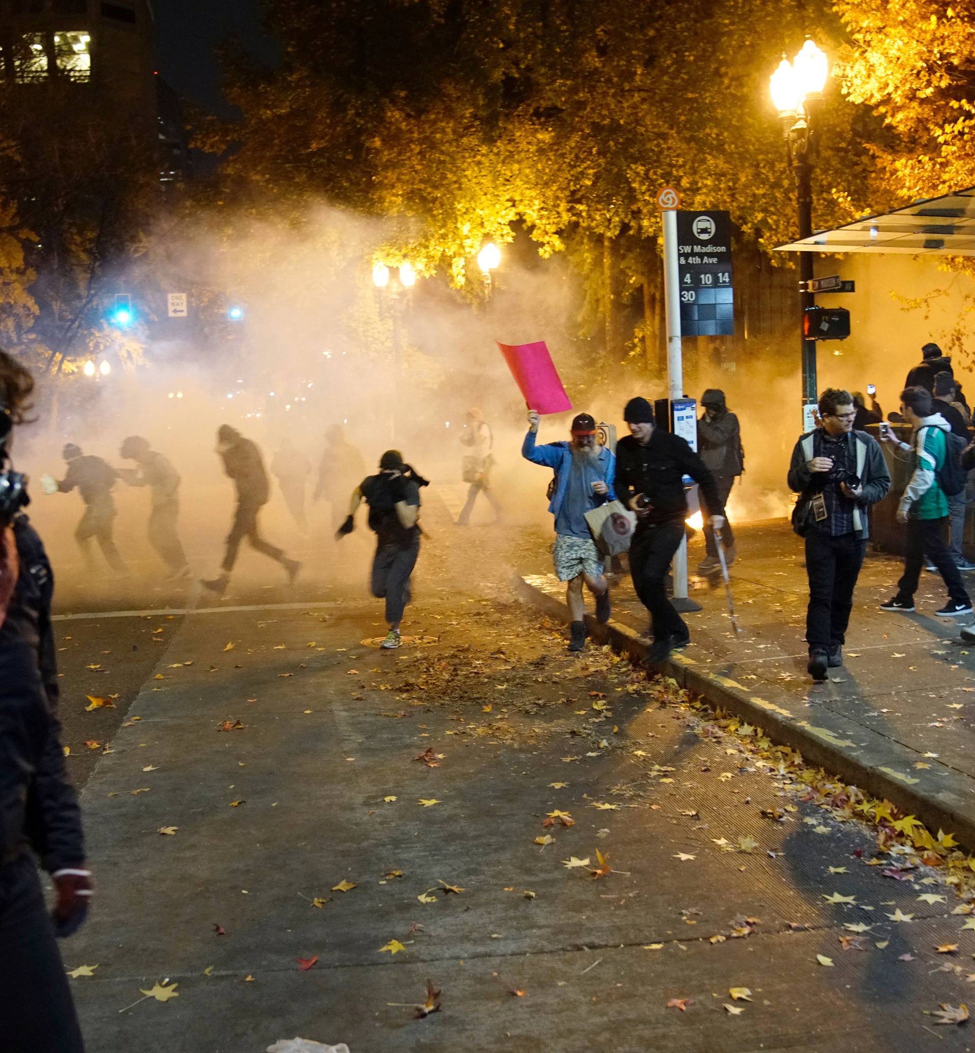 People try to move away from a gas cloud during a protest against the election of Republican Donald Trump as President of the United States in Portland, Oregon