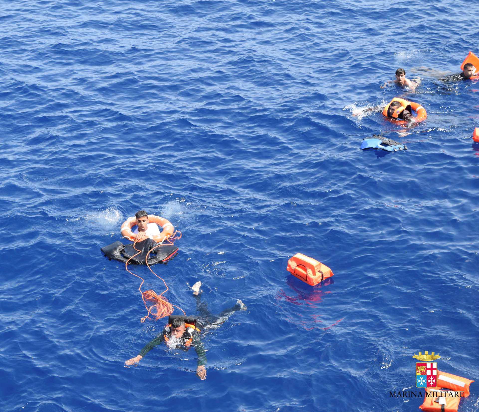 Migrants from a capsized boat are rescued during a rescue operation by Italian navy ships "Bettica" and "Bergamini" (unseen) off the coast of Libya