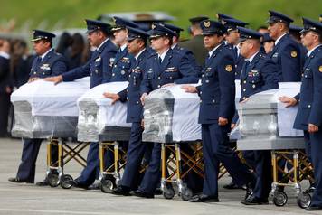 Military personnel unload a coffin with the remains of Brazilian victims who died in an accident of the plane that crashed into the Colombian jungle, at the airport from where the bodies will be flown home to Brazil, in Medellin