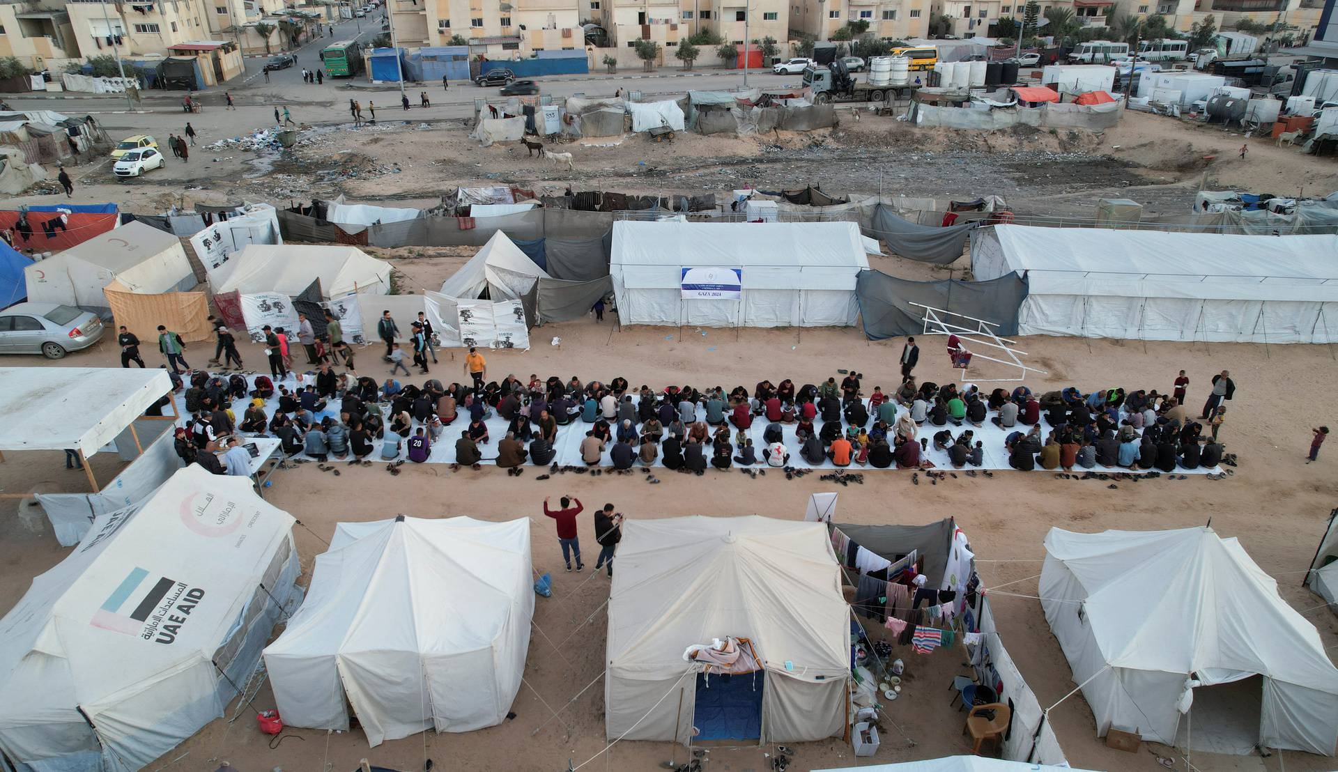 A drone view shows Palestinians, who were displaced by Israel's military offensive, gathering to have their Iftar (breaking of the fast) during the holy month of Ramadan, in Rafah in the southern Gaza Strip