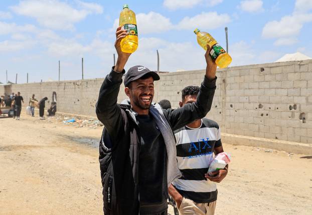 Palestinians carry aid supplies they received from the U.S.-backed Gaza Humanitarian Foundation, in Khan Younis