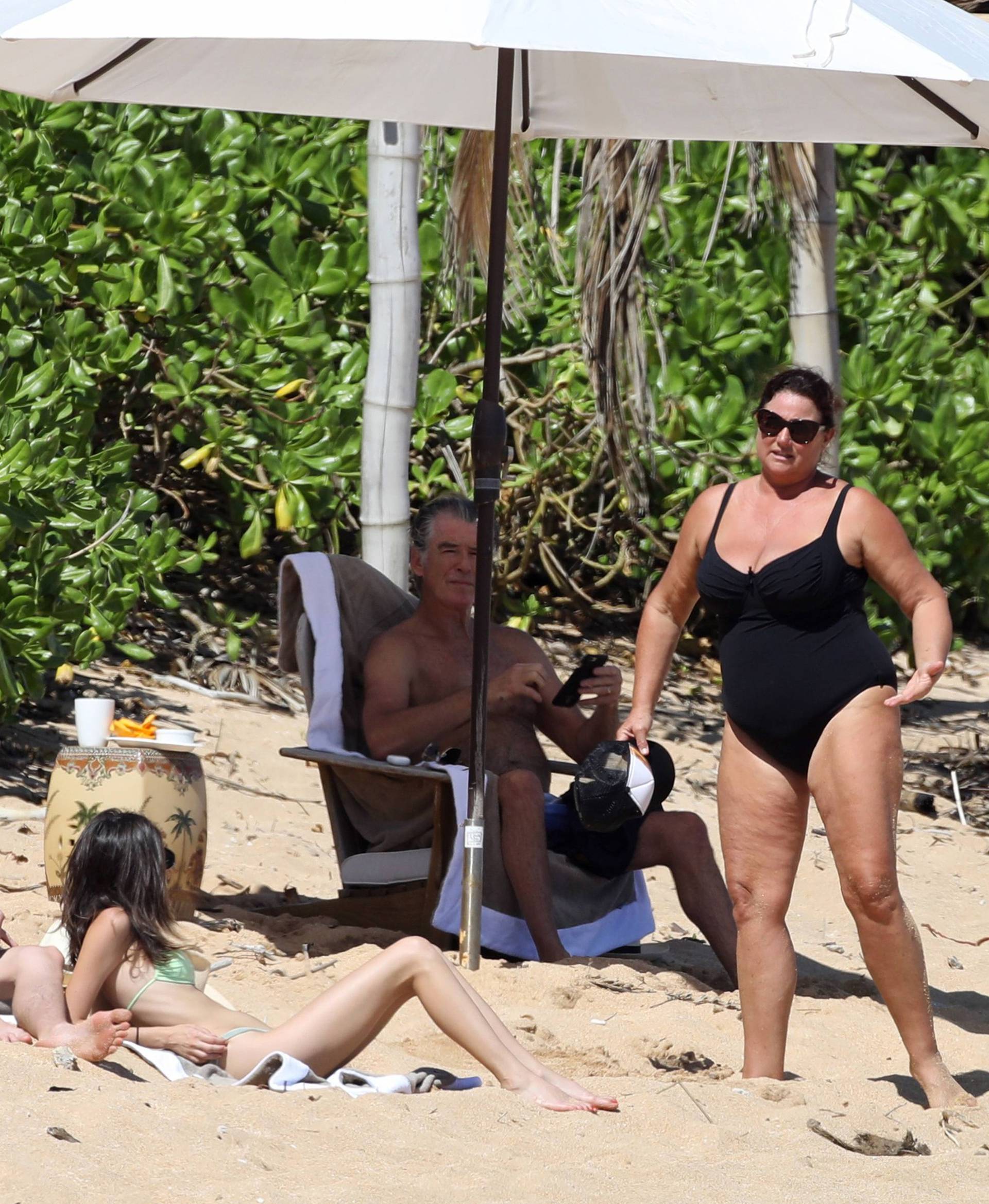 EXCLUSIVE: *NO WEB UNTIL 1530 EST 22ND MAR* Pierce Brosnan hits the beach in Hawaii with his wife Keely Shaye Smith and son Dylan, The former 007 star took a dip in the ocean before relaxing with the family under a umbrella on the beach.