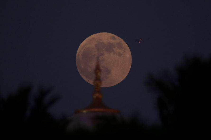 A lunar eclipse of a full "Blood Moon" rises behind the Sheikh Zayed Grand Mosque in Abu Dhabi