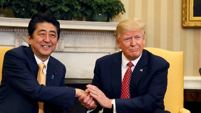 Japanese Prime Minister Abe shakes hands with U.S. President Trump during their meeting in the Oval Office at the White House in Washington