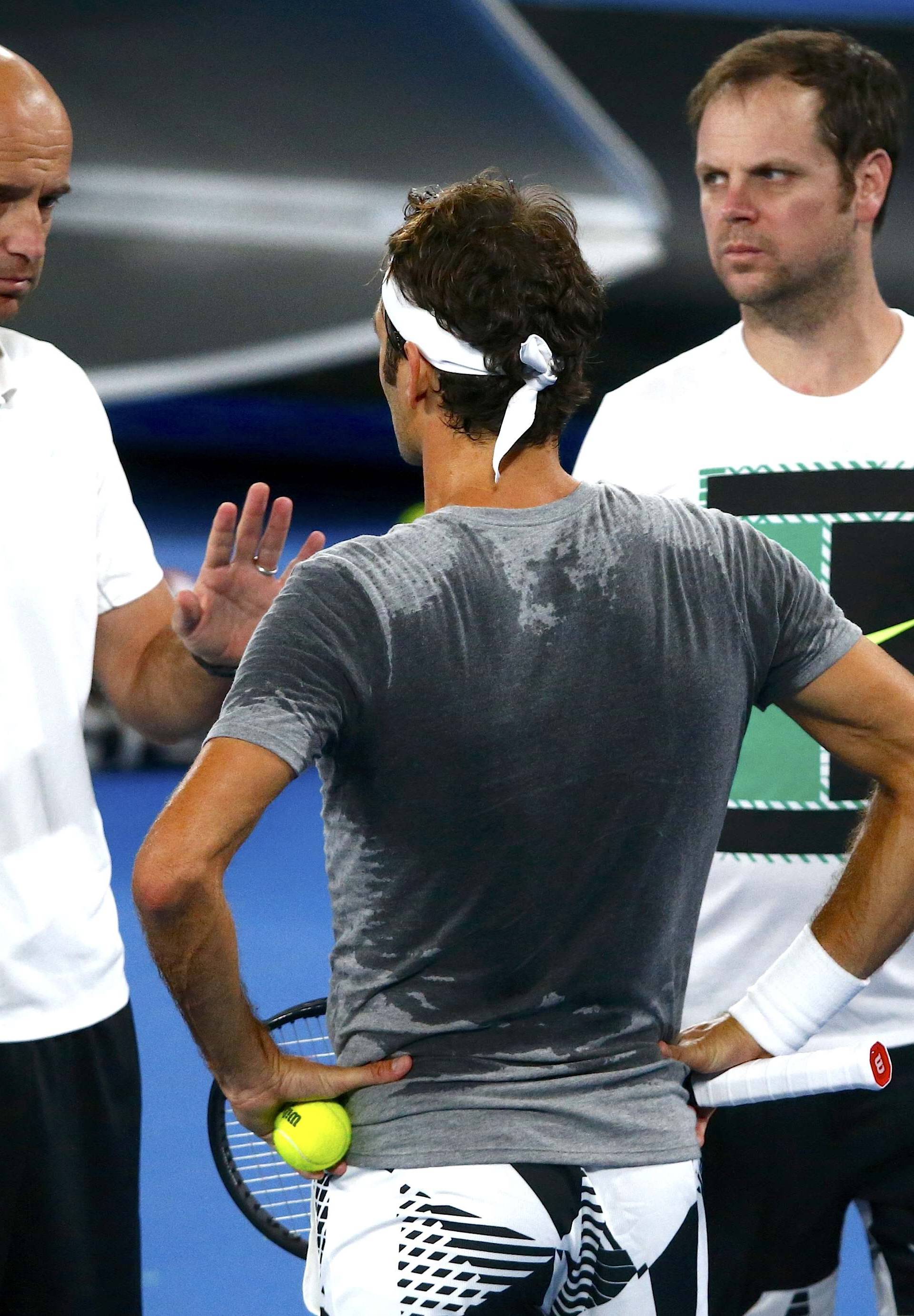 Switzerland's Roger Federer talks to his coaches Ivan Ljubicic and Severin Luthi during a training session ahead of the Australian Open tennis tournament in Melbourne