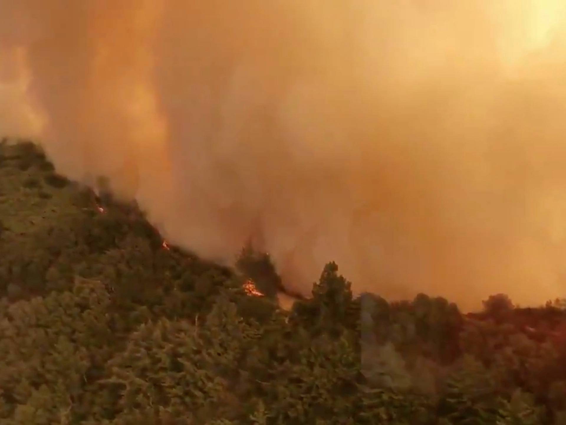 Aerial view of Trabuco Canyon as a tanker aircraft dumps load onto Holy Fire, California