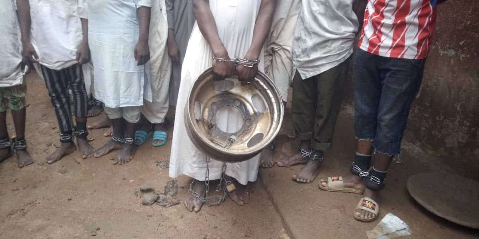 A handout picture from police shows people tied and chained after police raided a house freeing men and boys in Kaduna