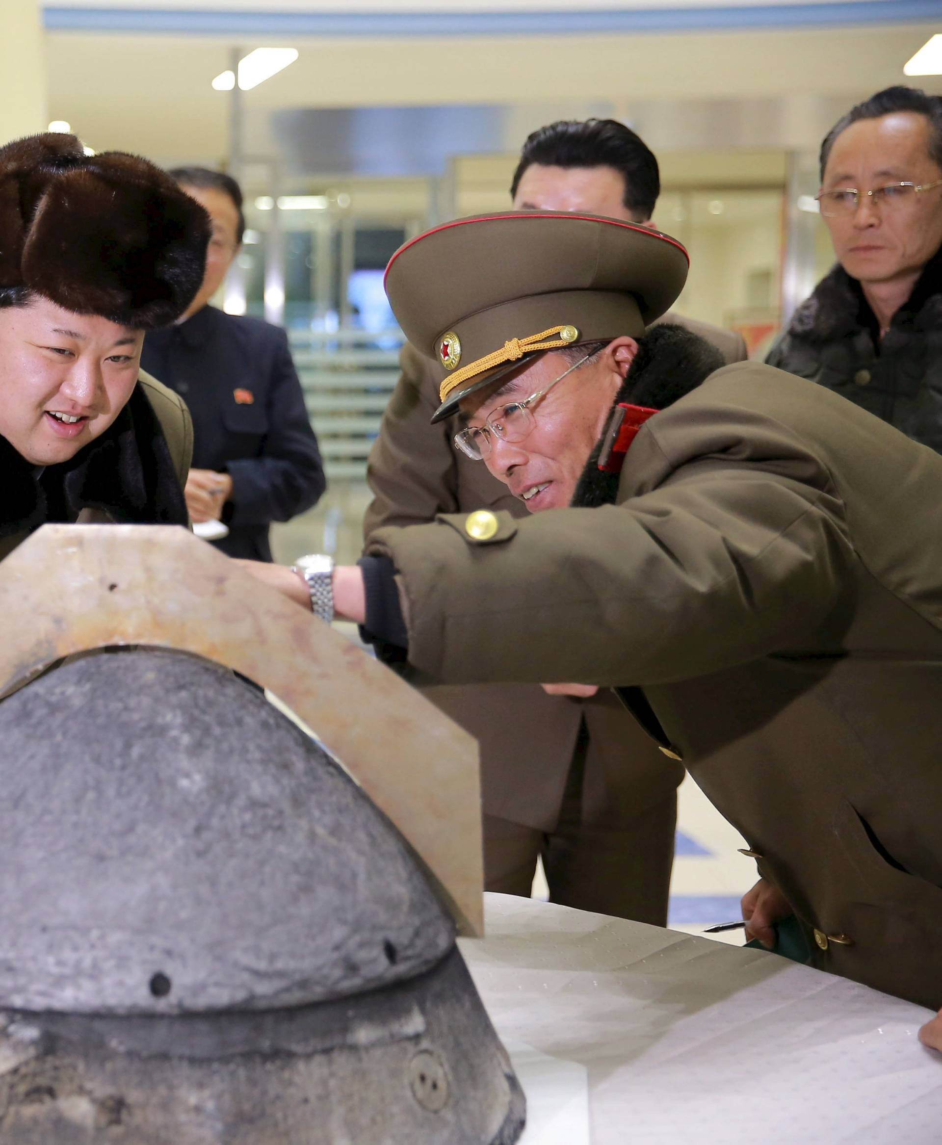 KCNA file picture shows North Korean leader Kim Jong Un looking at a rocket warhead tip after a simulated test of atmospheric re-entry of a ballistic missile