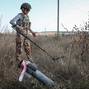 A member of the demining charitable fund 'Demining of Ukraine' works at a field near the town of Derhachi