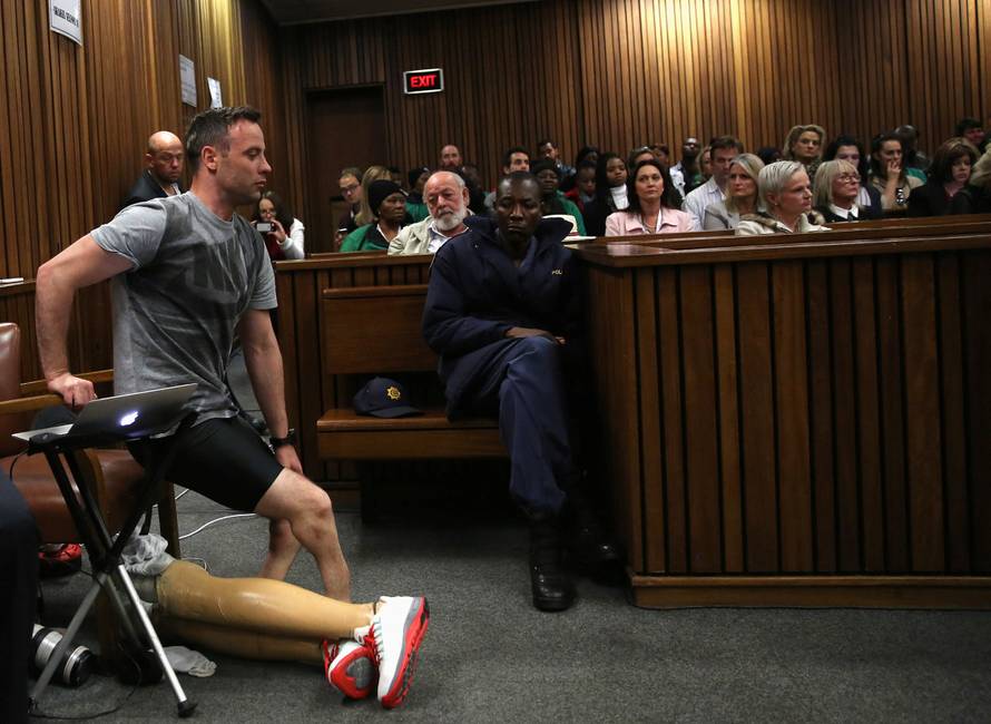 Paralympic gold medalist Oscar Pistorius prepares to walk across the courtroom without his prosthetic legs during the third day of the resentencing hearing for the 2013 murder of his girlfriend Reeva Steenkamp, at Pretoria High Court