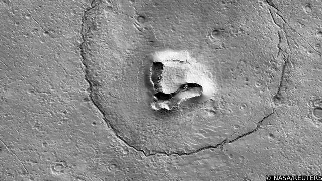 An undated image from NASA's Mars Reconnaissance Orbiter shows hills, craters and a circular fracture pattern on the surface of Mars