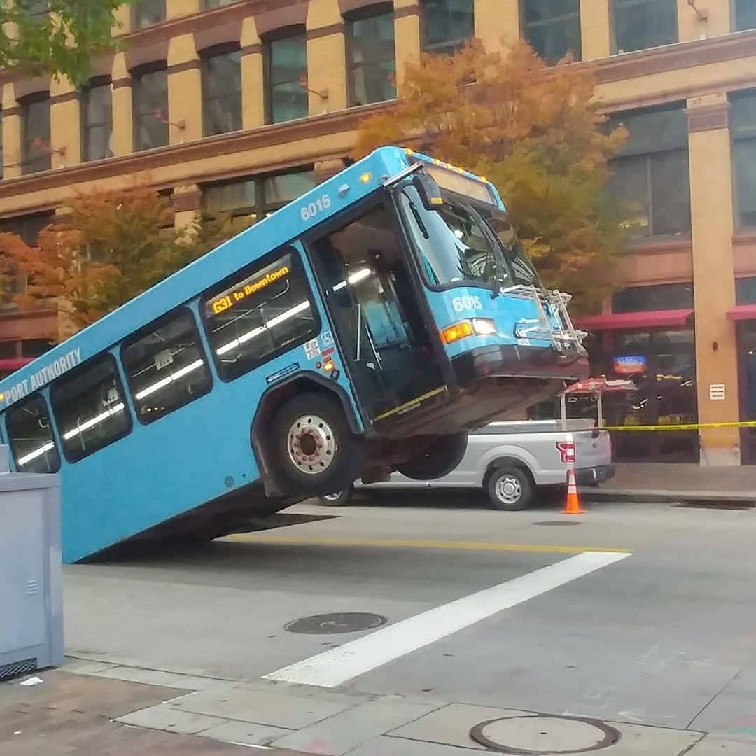 Front of a public bus sticks out of a sinkhole on 10th and Penn Avenue in Pittsburgh