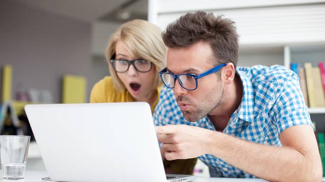 Two,Surprised,Students,Learning,In,Library,On,Laptop