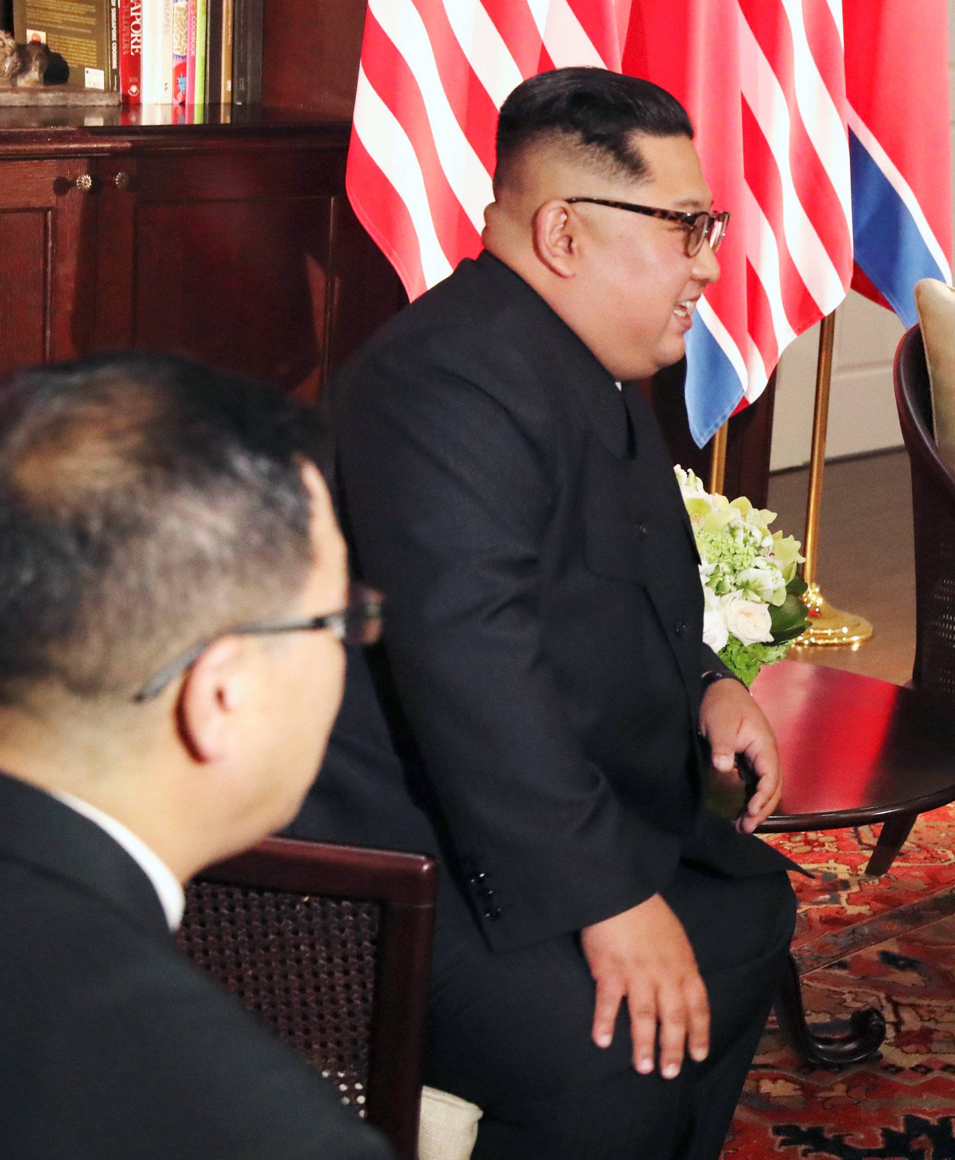 U.S. President Donald Trump gestures next to North Korea's leader Kim Jong Un before their meeting in Singapore