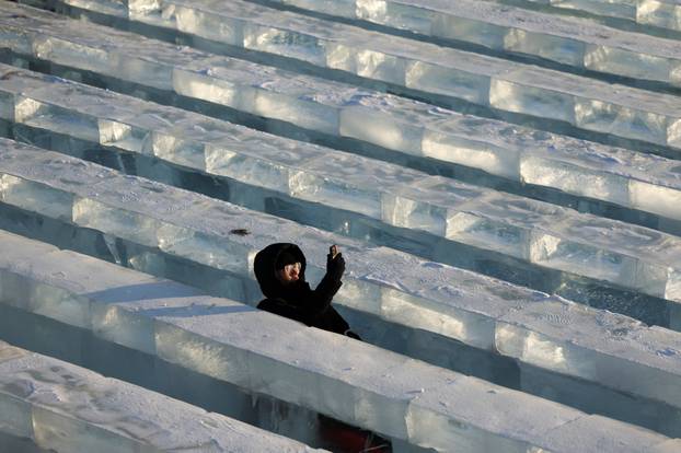 A person slides down an ice slide at the annual Ice and Snow Festival in Harbin