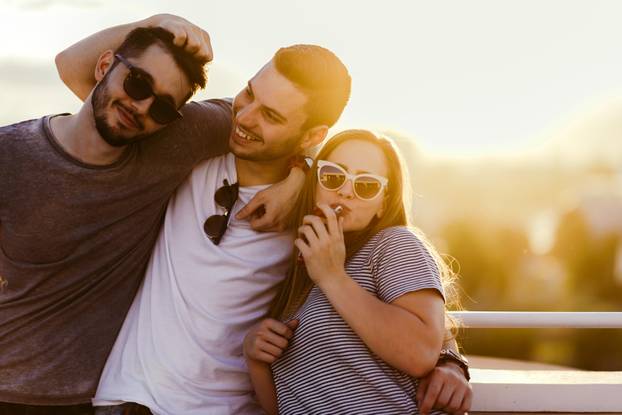 Group of carefree smiling friends are hugging on the top of the 