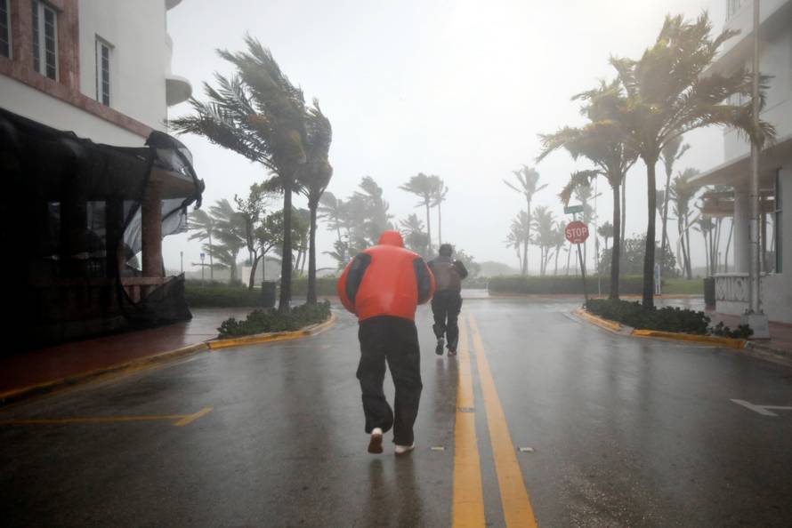 People walk along a street in South Beach as Hurricane Irma arrives at south Florida, in Miami Beach