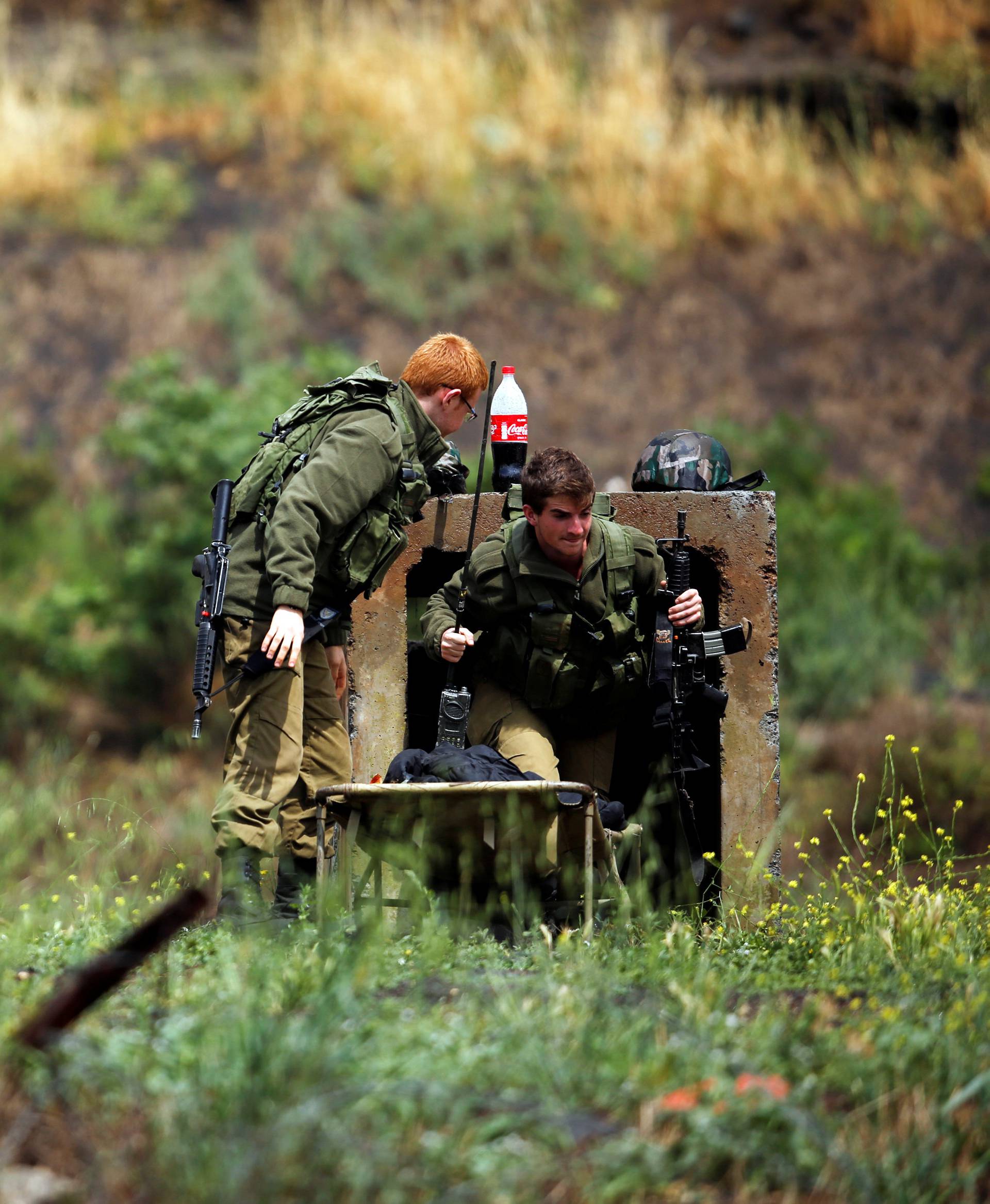 Israeli soldiers can be seen near the Israeli side of the border with Syria in the Israeli-occupied Golan Heights