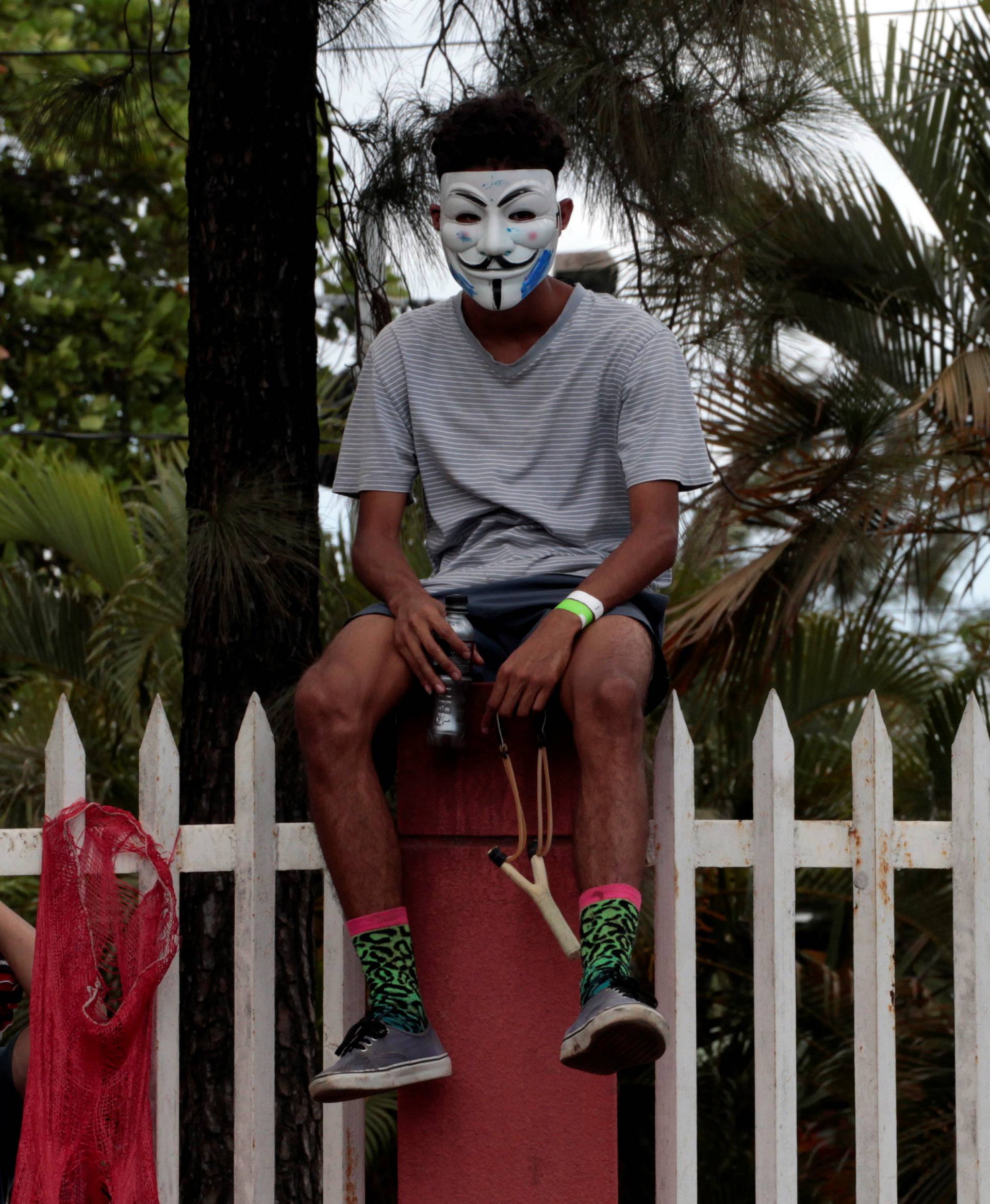 A demonstrator sits outside a university during a protest in Managua
