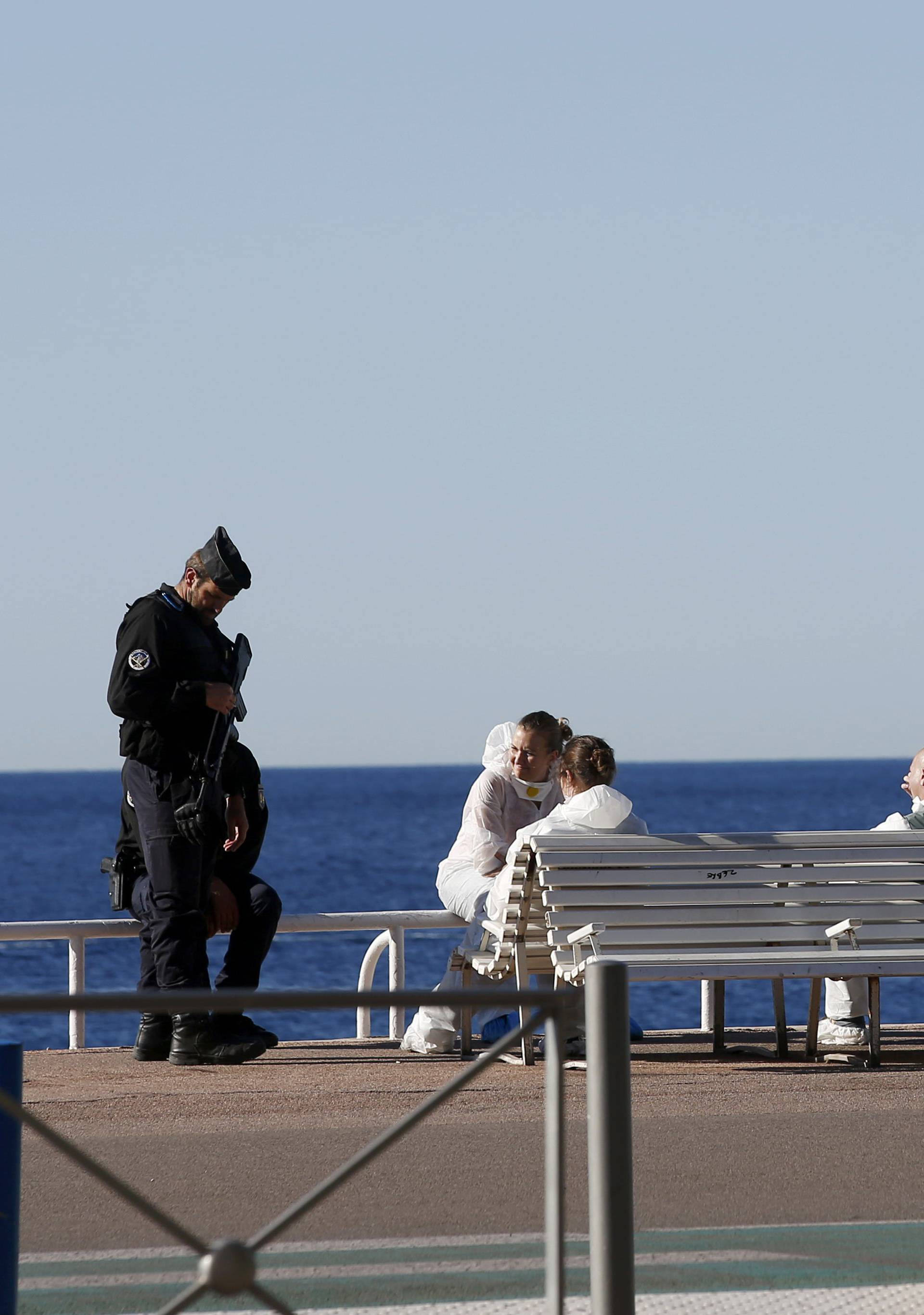 French police and investigators gather on the beachfront as a French Navy ship patrols the day after a truck ran into a crowd at high speed killing scores celebrating the Bastille Day July 14 national holiday on the Promenade des Anglais in Nice
