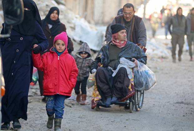 People walk as they gather to be evacuated from a rebel-held sector of eastern Aleppo