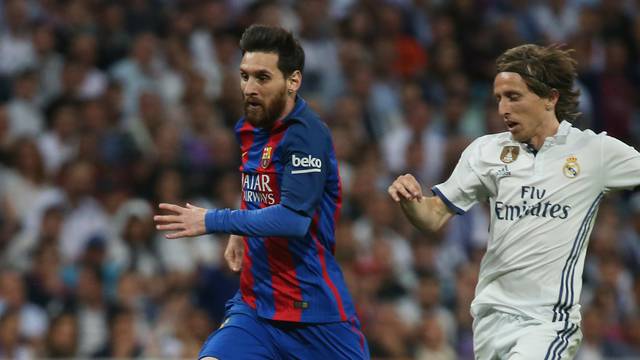 Real Madrid's Luka Modric in action with Barcelona's Lionel Messi
