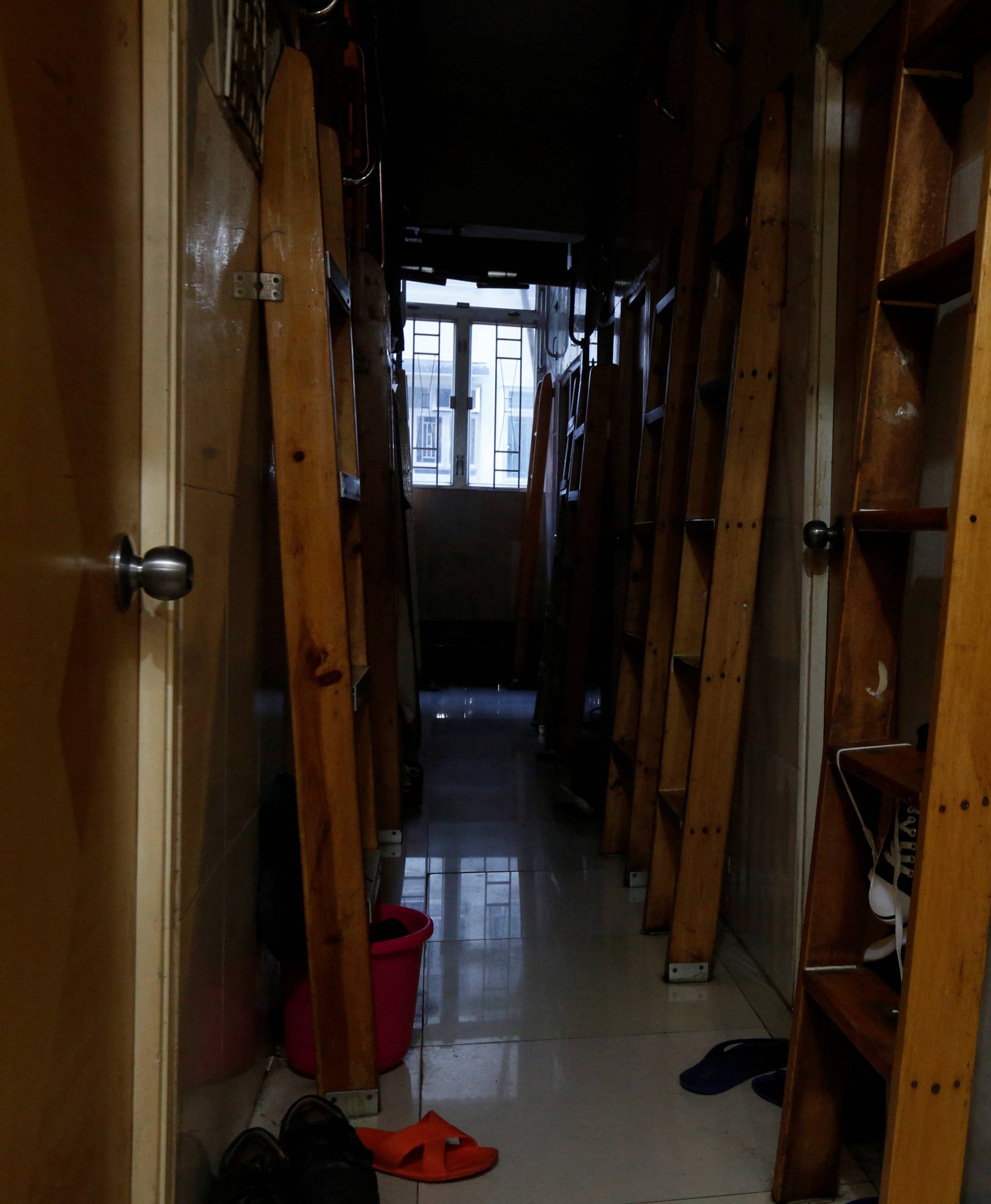 A corridor with ladders is seen inside a flat filled with partitioned units, or "coffin units", in Hong Kong