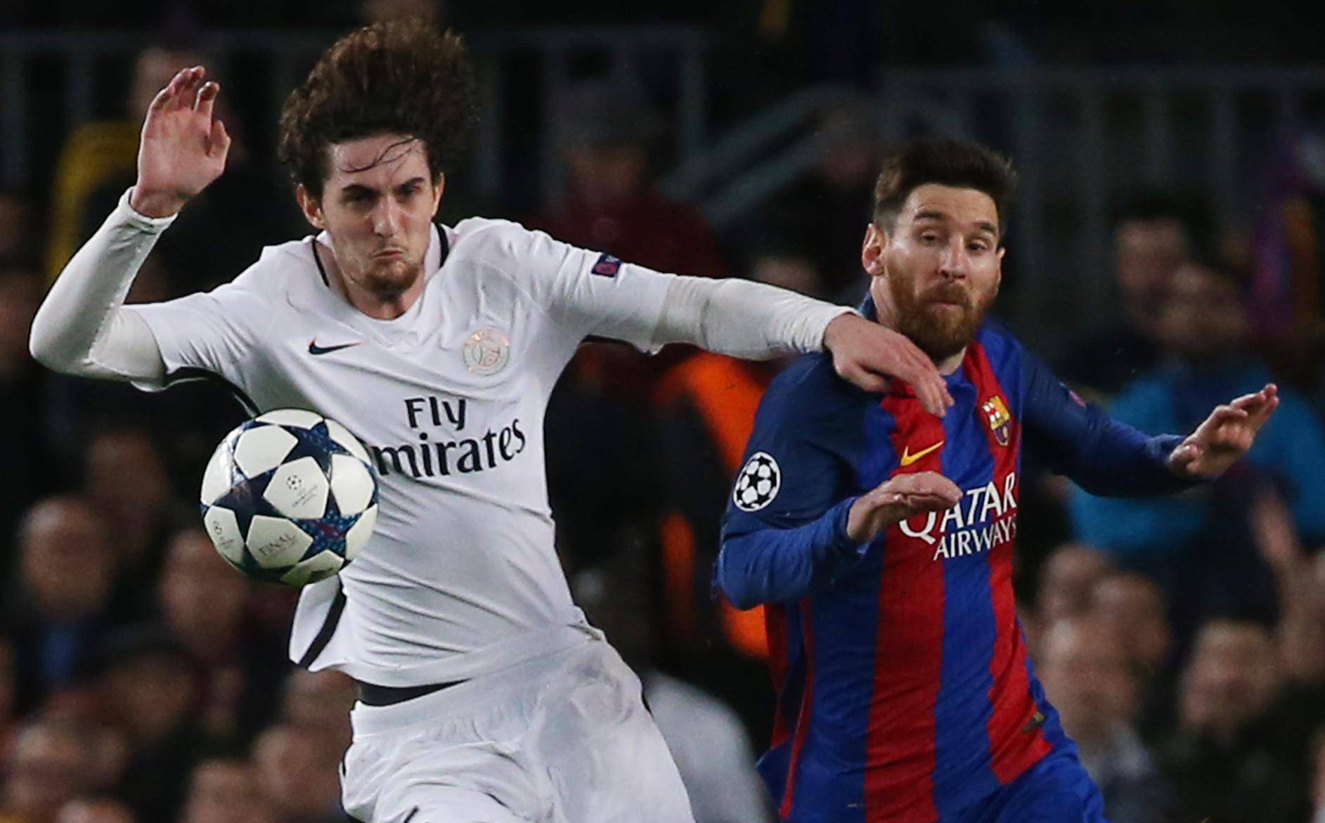 Paris Saint-Germain's Adrien Rabiot in action with Barcelona's Lionel Messi