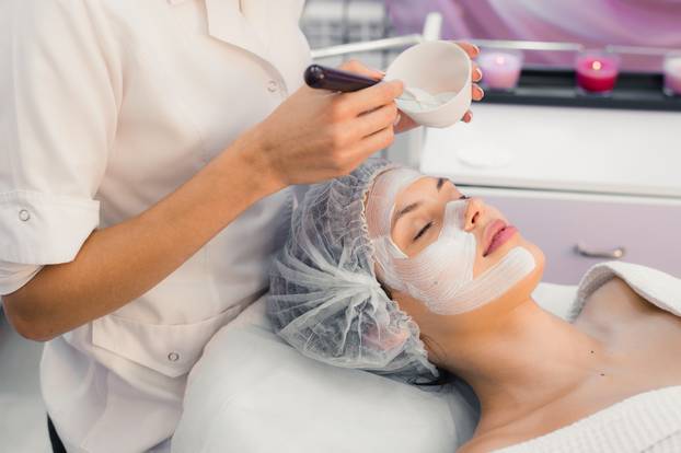 Young beautiful woman having spa procedure on her face