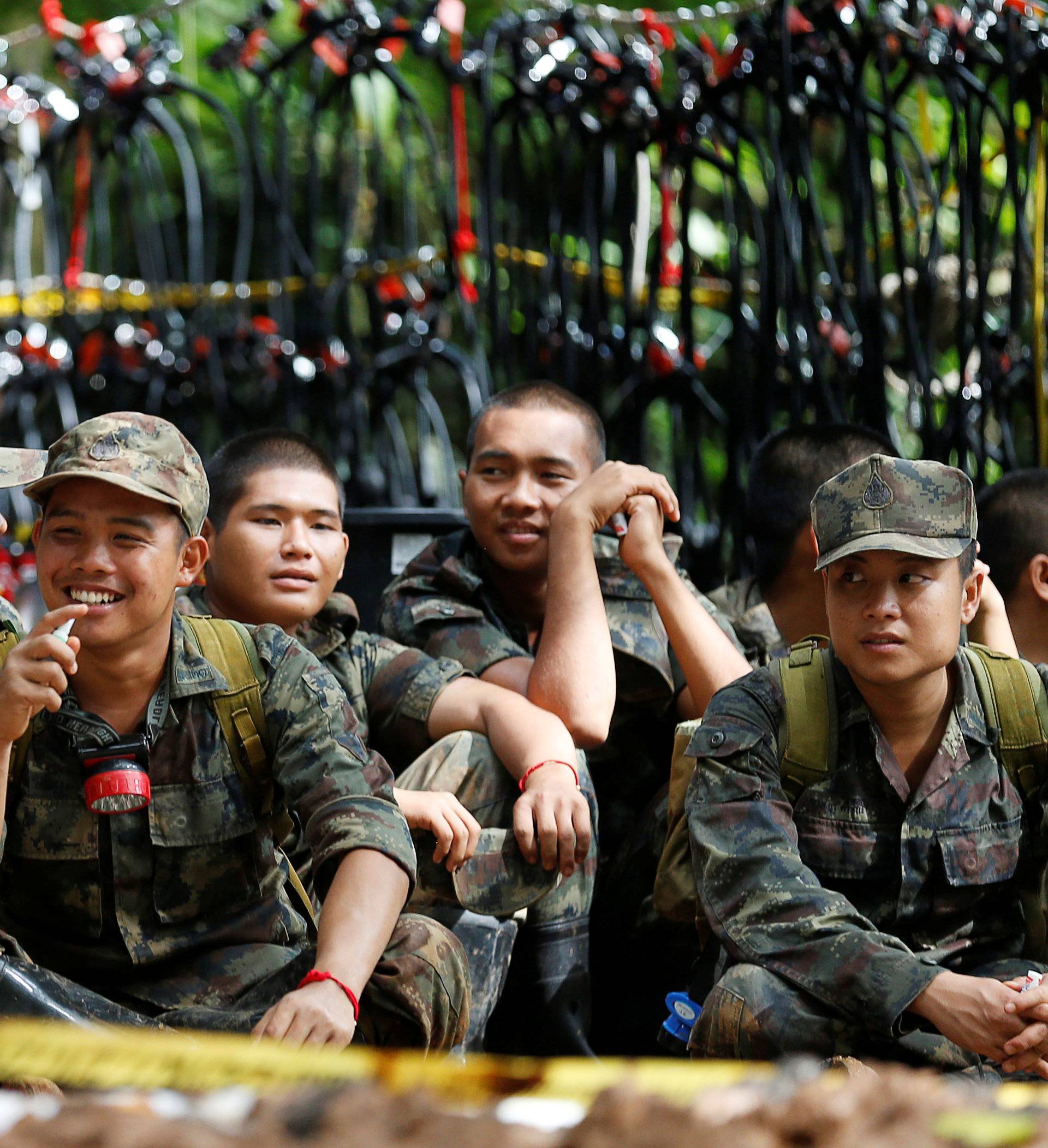 Police and rescue workers pass their time near the Tham Luang cave complex, as members of an under-16 soccer team and their coach have been found alive according to local media in the northern province of Chiang Rai