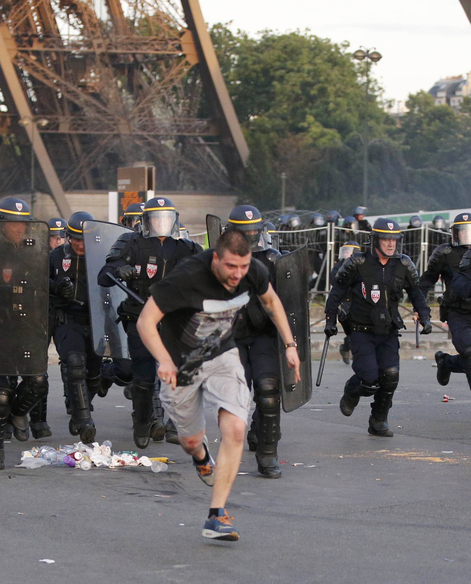 French CRS riot police charge during clashes outside the Paris fan zone during a EURO 2016 final soccer match       