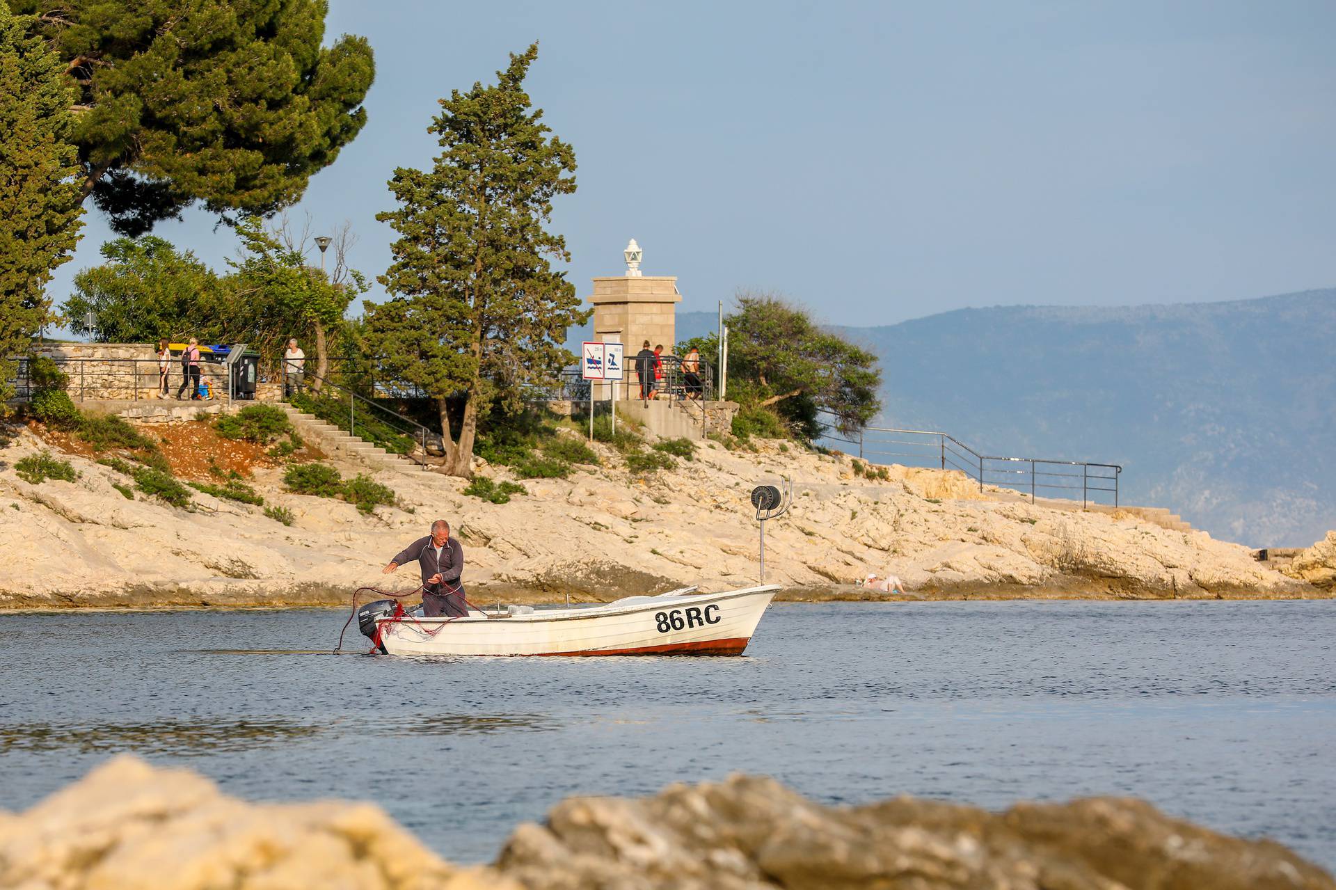 Rabac: Ribar baca mrežu u more