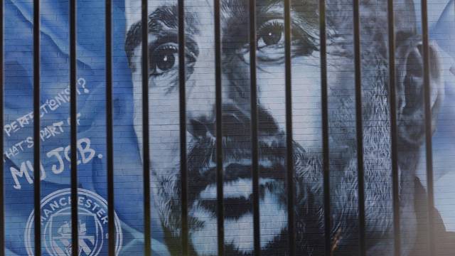A mural of Manchester City manager Pep Guardiola is seen after Manchester City were charged with breaking financial rules by the Premier League