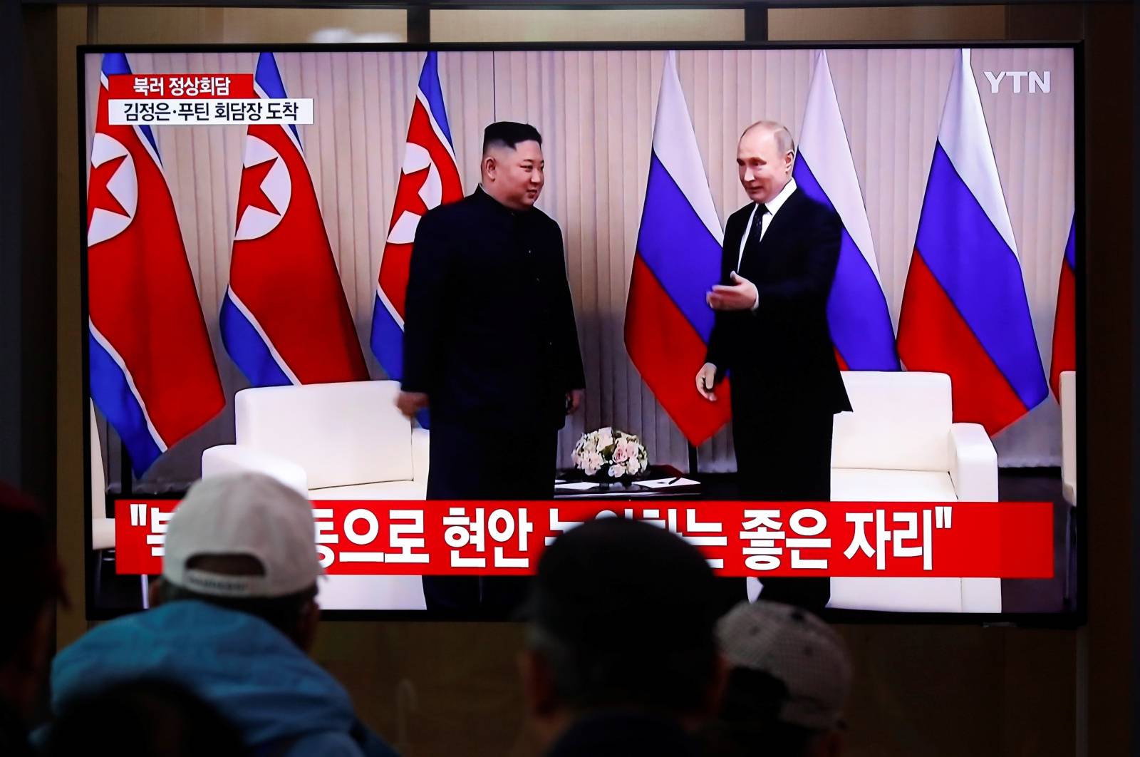 South Korean people watch a TV broadcasting a live news on a meeting between North Korean leader Kim Jong Un and Russia President Vladimir Putin, in Seoul