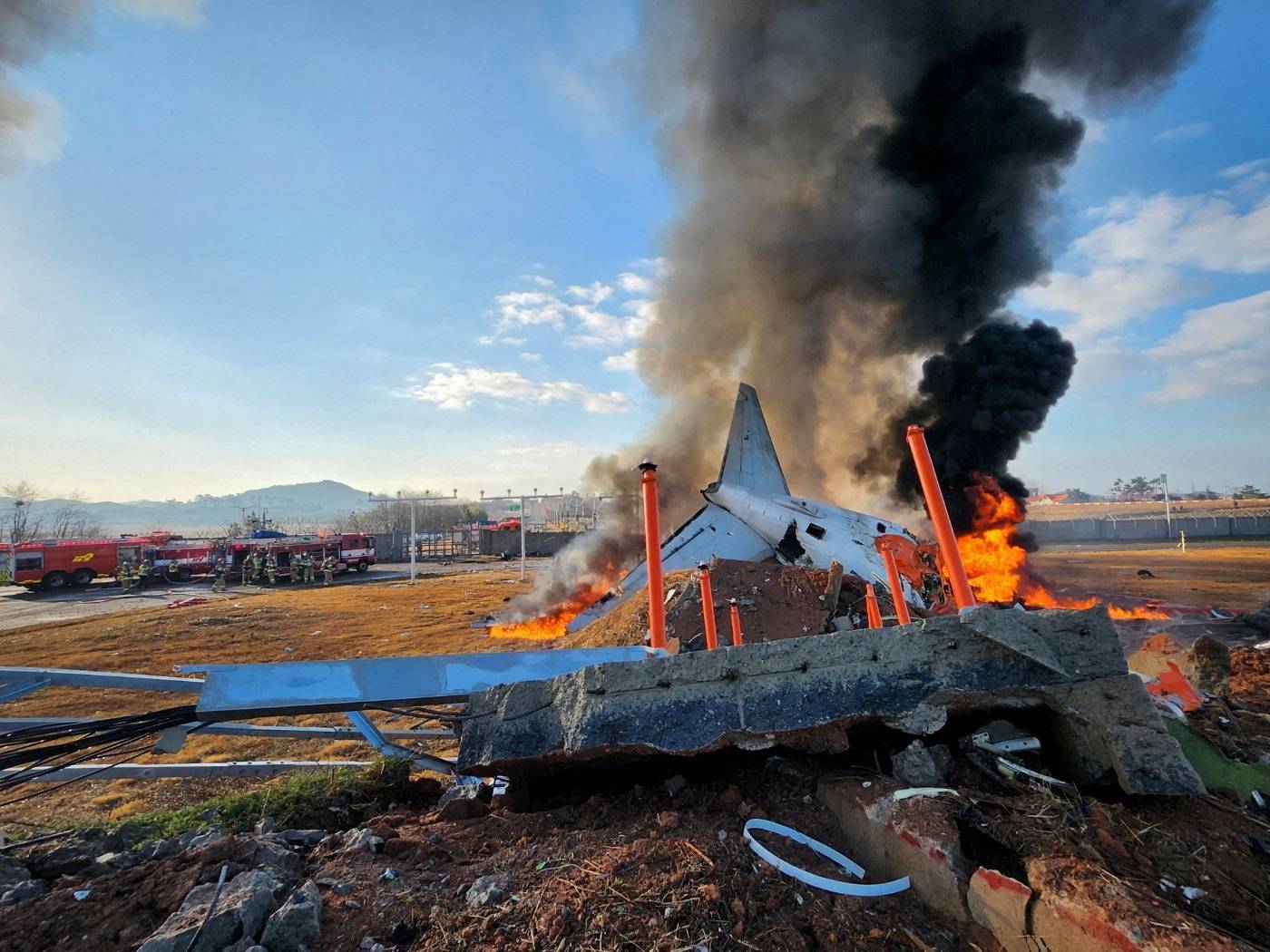 Firefighters carry out extinguishing operations on an aircraft which drove off runway at Muan International Airport in Muan