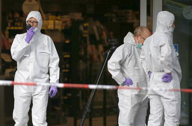 Police investigators work at the crime scene after a knife attack in a supermarket in Hamburg