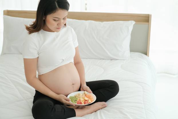 Asia husband take care pregnant wife and eat mixed fruits