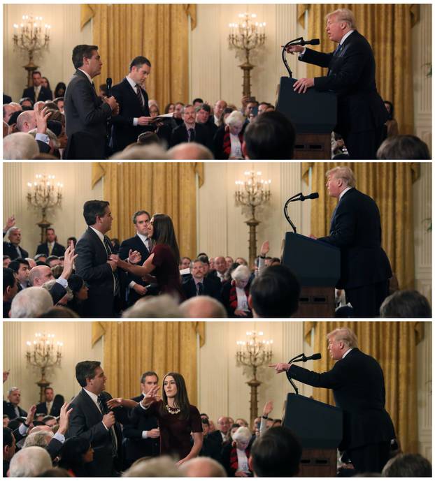 A White House staff member reaches for the microphone held by CNN