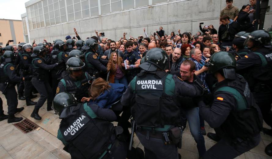 People scuffle with Spanish Civil Guard officers outside a polling station for the banned independence referendum in Sant Julia de Ramis