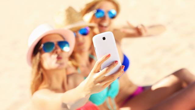 Group of friends taking selfie on the beach