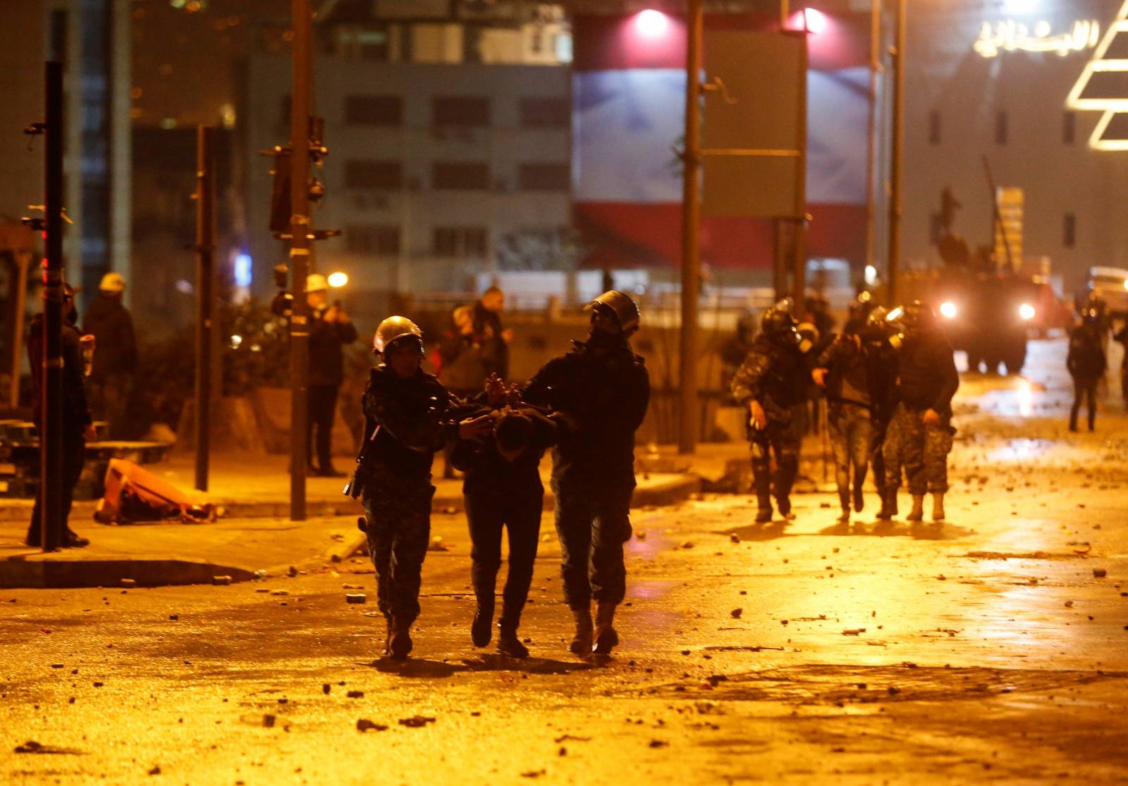 Riot police restrain a protestor during a protest against a ruling elite accused of steering Lebanon towards economic crisis in Beirut