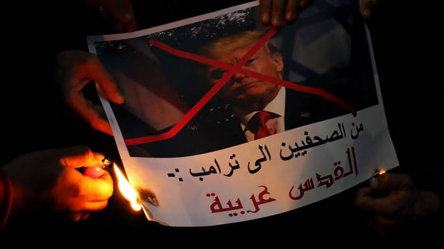 People burn a poster of Trump reading "Journalists are telling you Trump, Jerusalem is Arab" during a protest against Trump's Jerusalem declaration, in front of the Syndicate of Journalists in Cairo