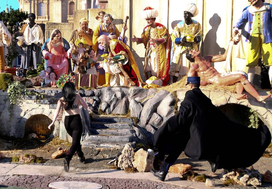 A Vatican gendarme attempts to block a topless activist of women's rights group Femen, who tries to reach the Nativity scene in Saint Peter's square in the Vatican