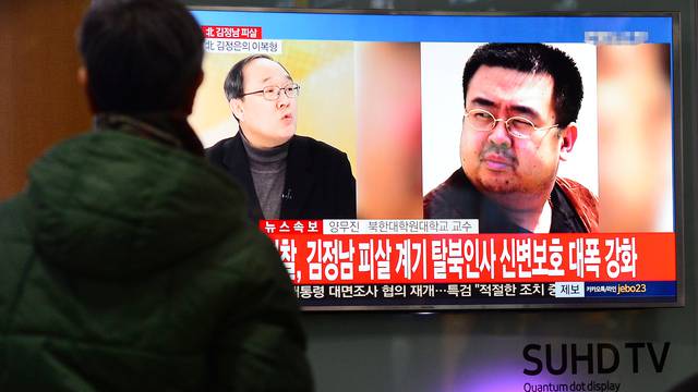 People watch a TV screen broadcasting a news report on the assassination of Kim Jong Nam, the older half brother of the North Korean leader Kim Jong Un, at a railway station in Seoul