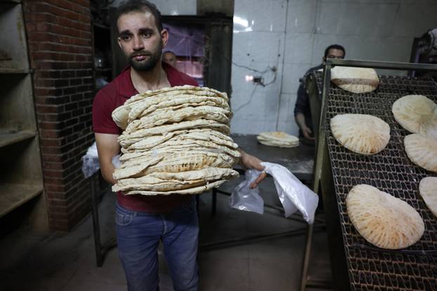 People queue to buy bread in Damascus